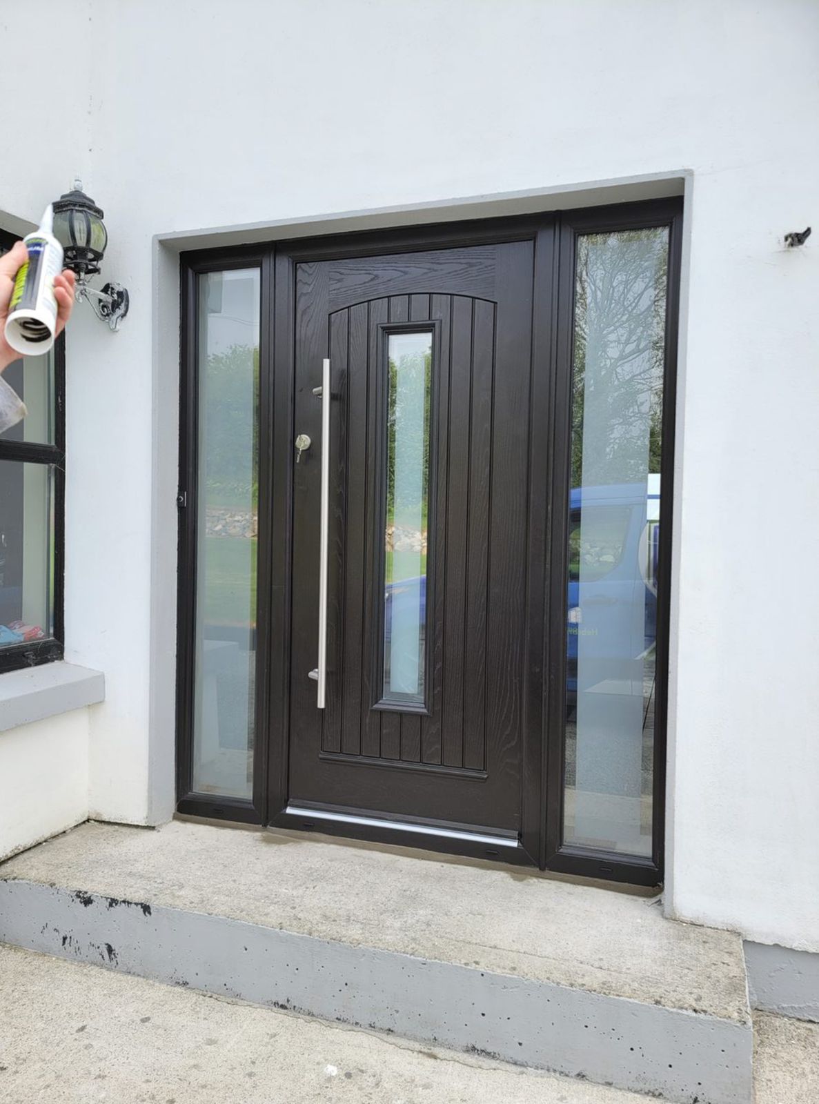 Black front door with side panels and bar handle