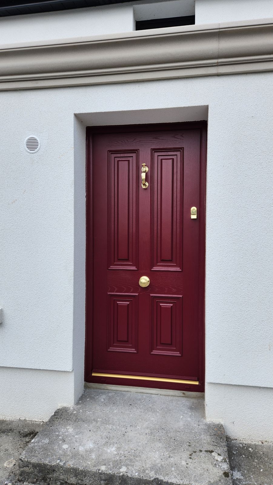 Burgundy panelled door with brass furniture