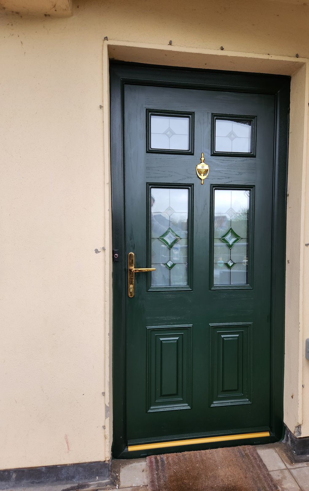 Dark green front door with leaded glass